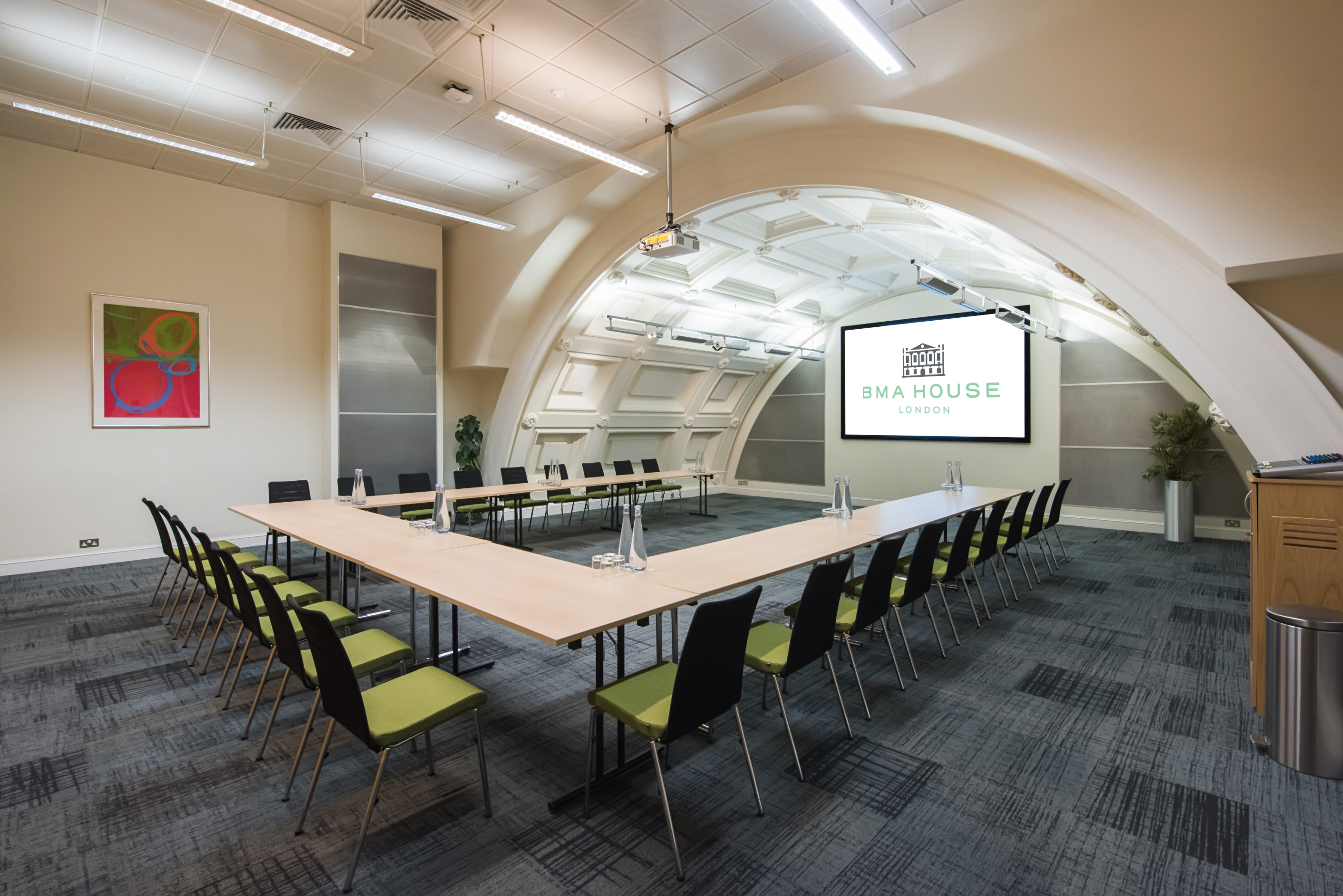 Modern meeting room with U-shaped table, ideal for workshops and strategic planning.