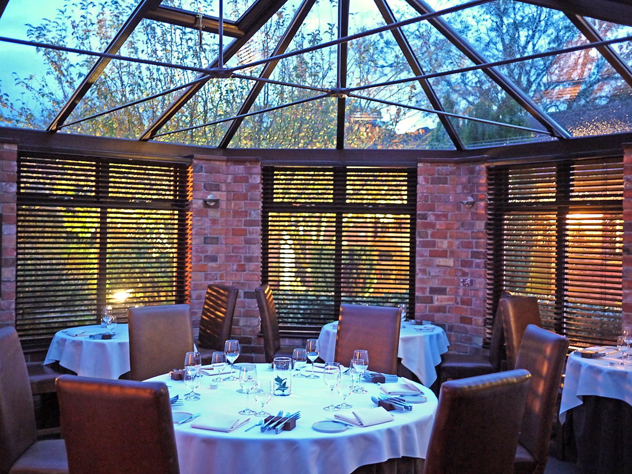 Elegant dining area with glass ceiling for private dinners and meetings at Restaurant Sat Bains.