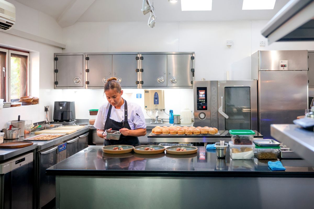 Chef preparing dishes at restaurant kitchen for catering events and meetings.