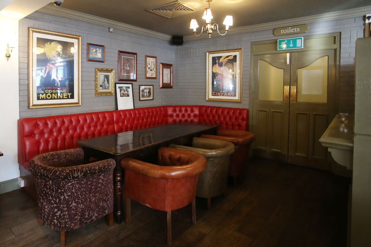 Cozy meeting space with red tufted bench, ideal for casual events and group discussions.