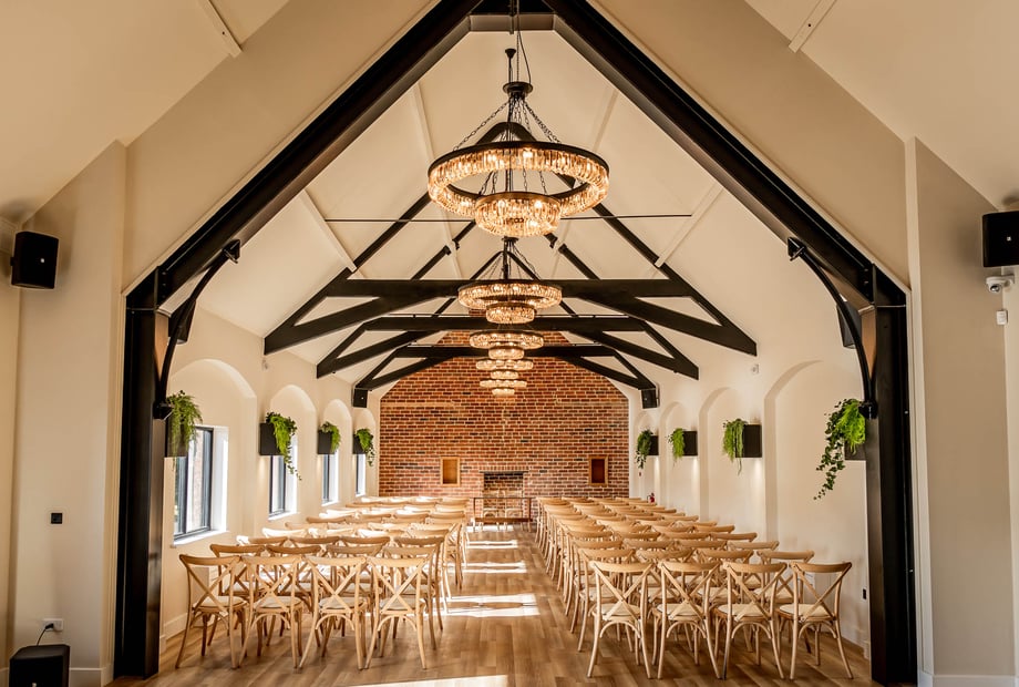 Spacious meeting room with elegant chandeliers, ideal for corporate events and weddings.