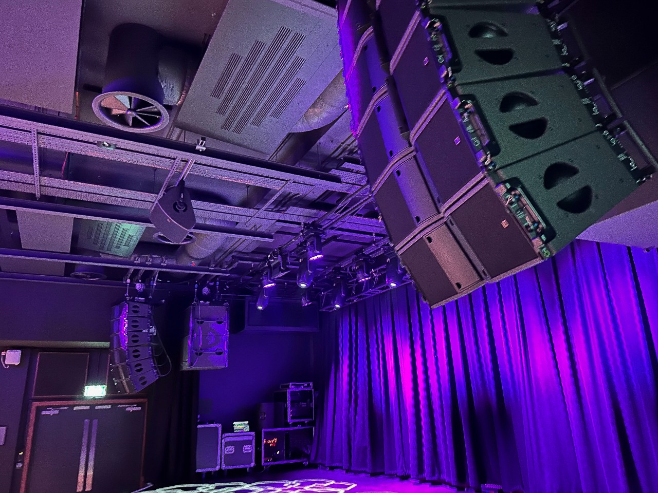 Main Stage at Metronome with purple curtains, ideal for concerts and corporate events.
