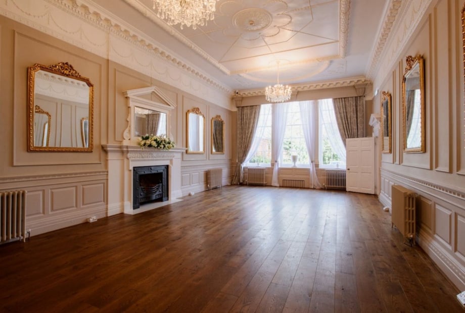 Elegant event space with polished floors and chandelier at The Bell Inn's Crown Post Room.