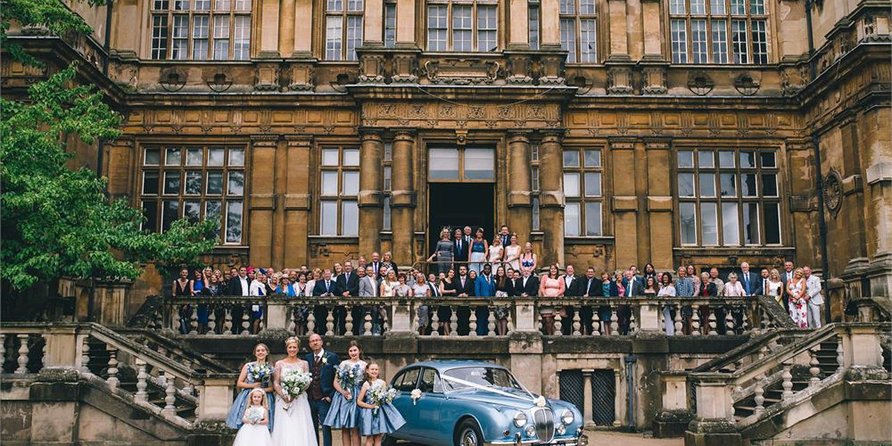 Wollaton Hall Great Hall: elegant wedding venue with classic car and picturesque decor.