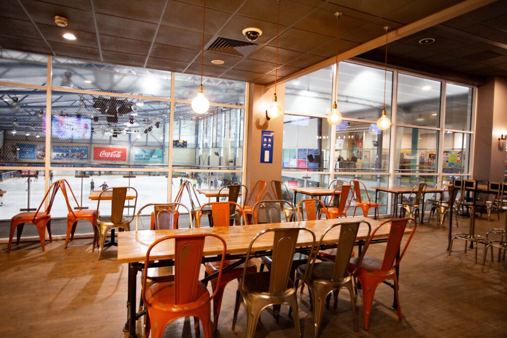 T&D Café at Motorpoint Arena: modern event space with ice rink view for team-building events.