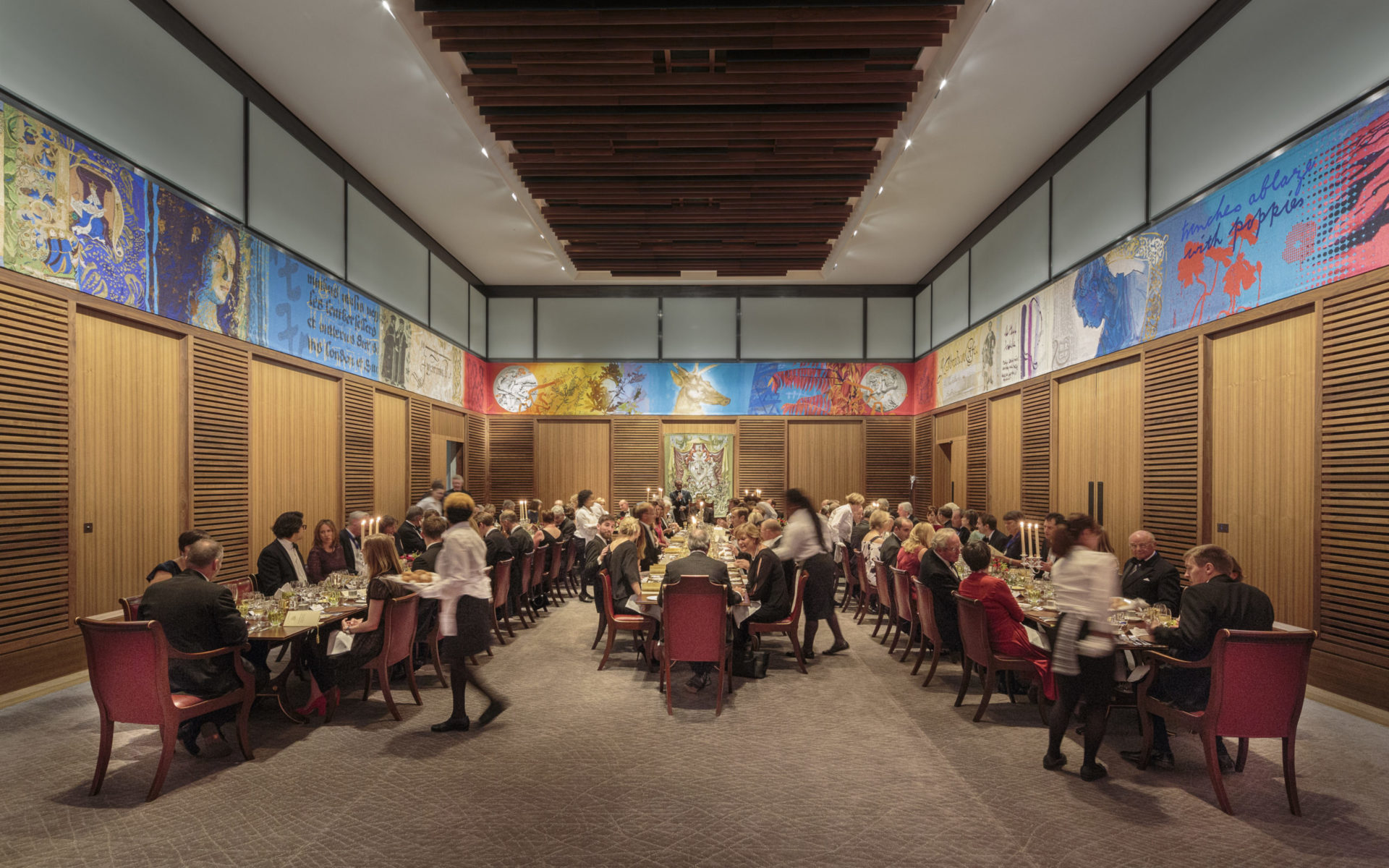 Elegant dining hall banquet with guests, murals, ideal for networking events.