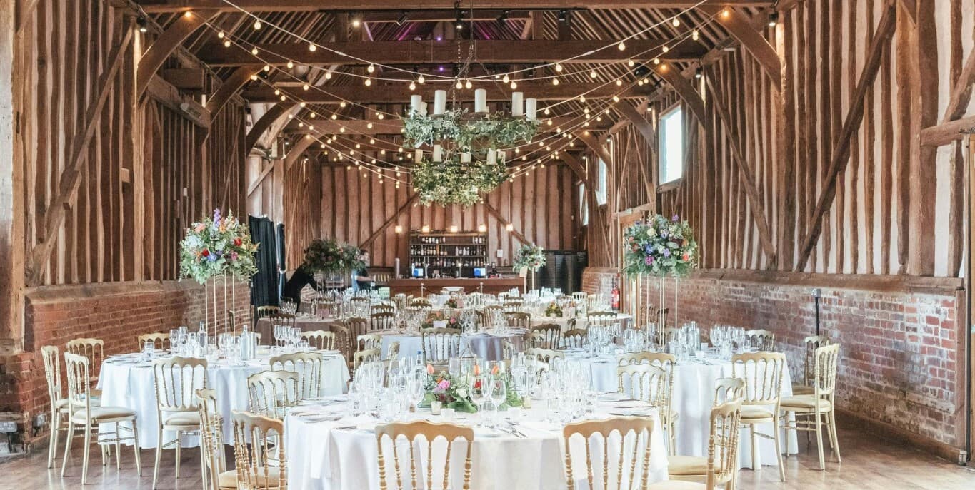 Elegant barn wedding venue at Lillibrooke Manor, featuring rustic decor and floral centerpieces.