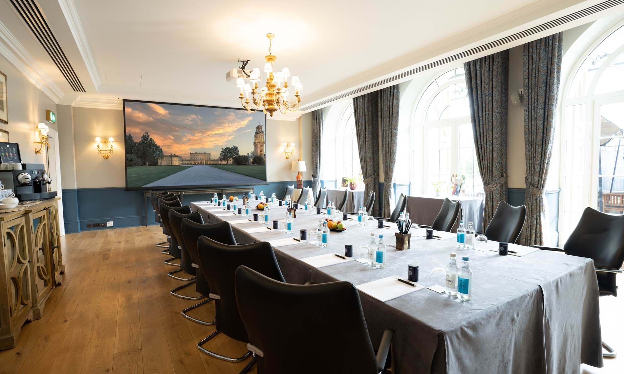 Boardroom setup at The Churchill, Cliveden House with AV screen for executive strategy meetings.