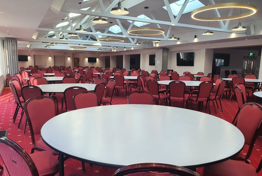 Spacious Navnat Centre dining hall with round tables for conferences and banquets.