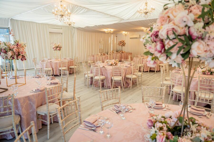Elegant banquet hall with pink tablecloths, ideal for weddings and upscale events.
