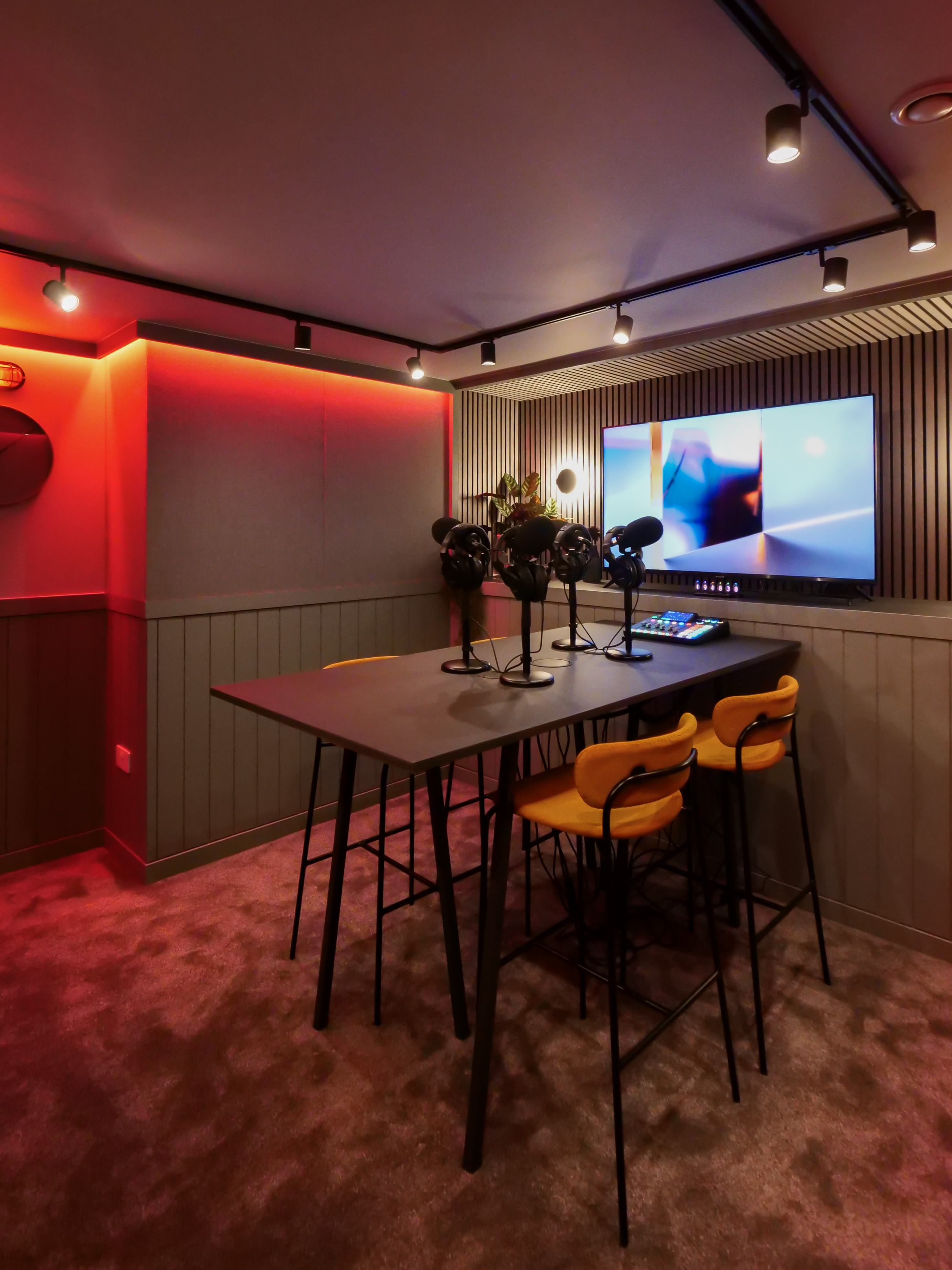 Modern podcast room with vibrant chairs and microphones for creative meetings.