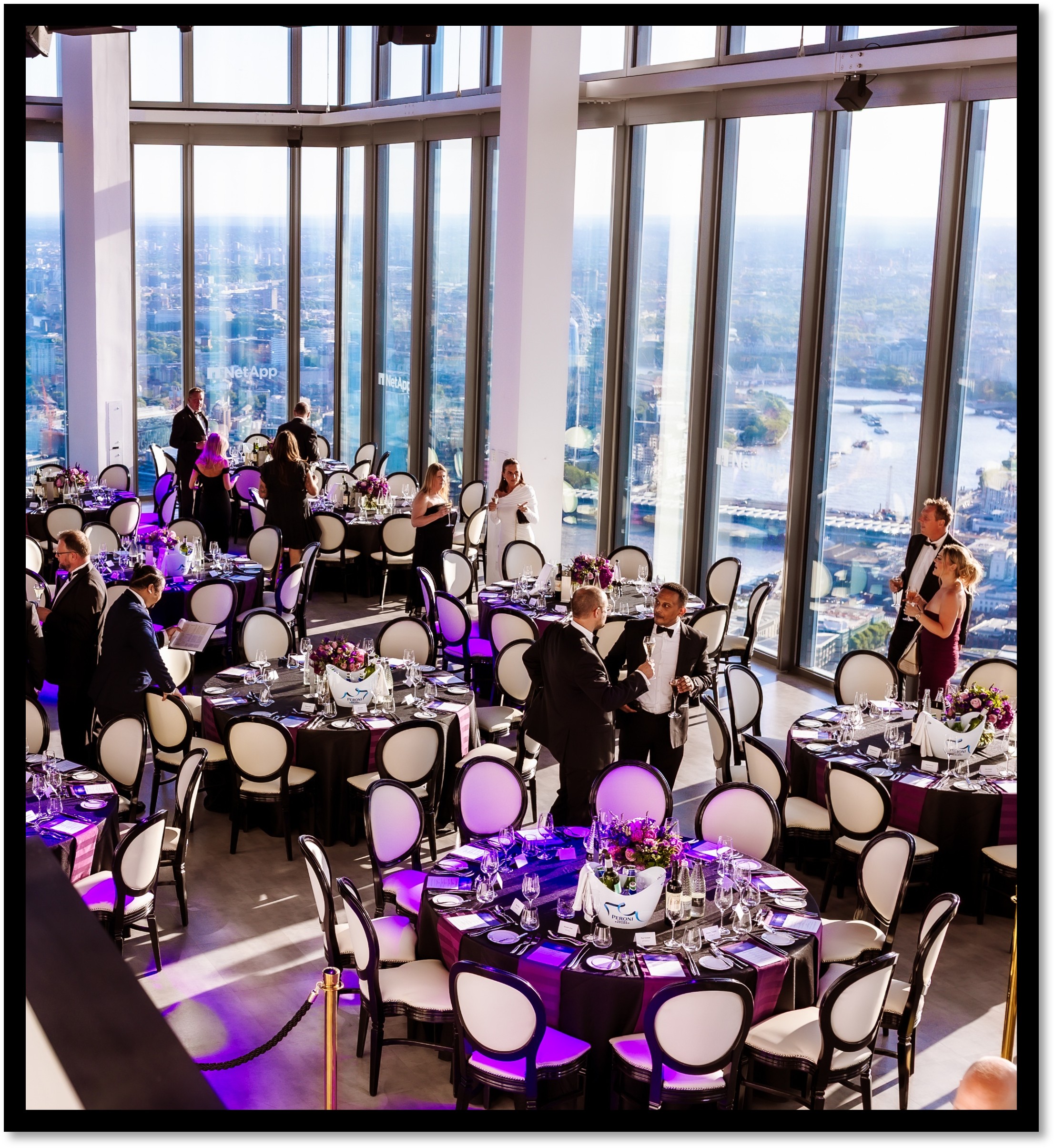 Elegant city gala venue, purple uplighting, formal dinner.
