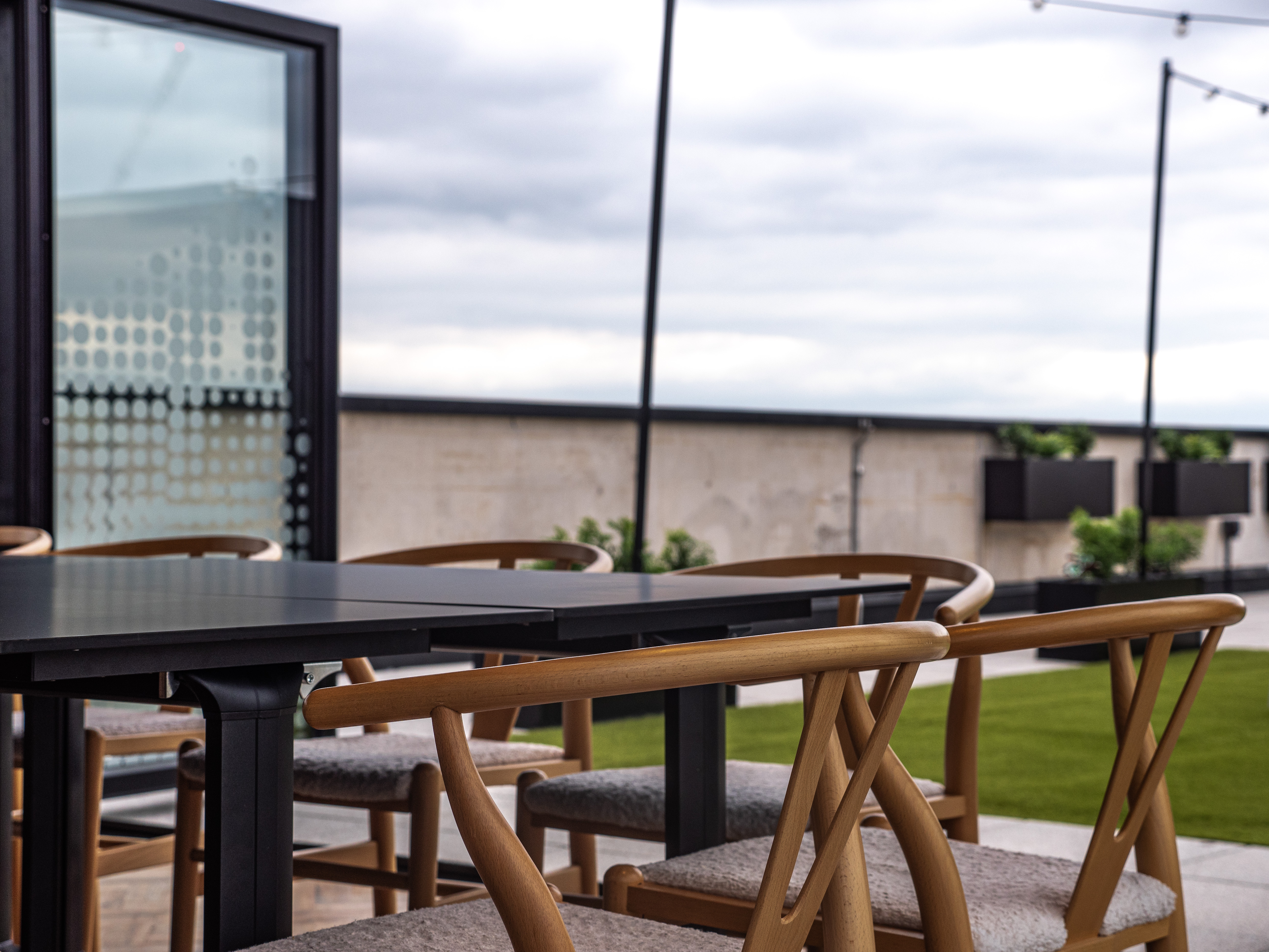 Outdoor meeting space at The Observatory, featuring a sleek table and chairs for gatherings.