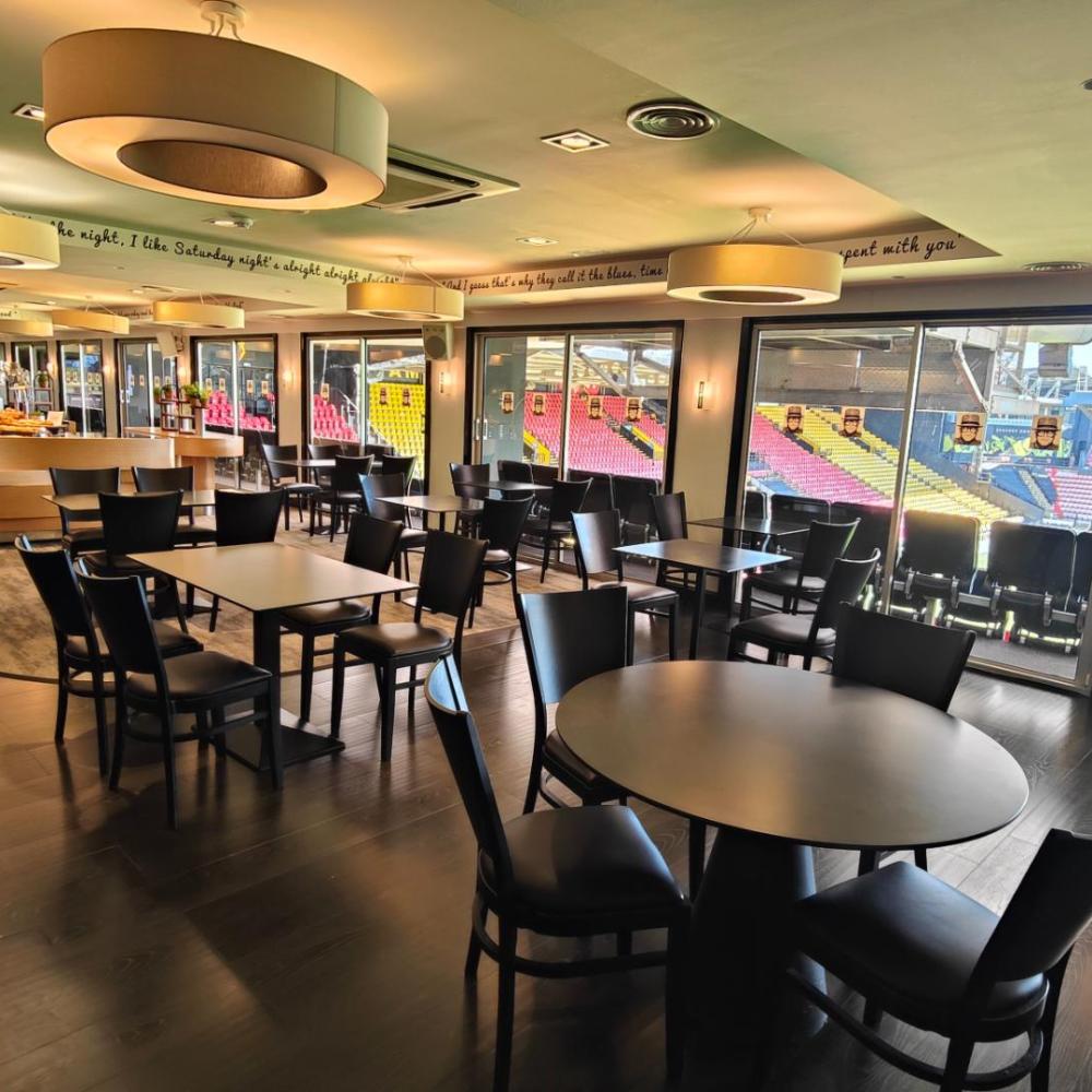 "Modern event space with sleek furniture and natural light at Watford F.C. for corporate events."