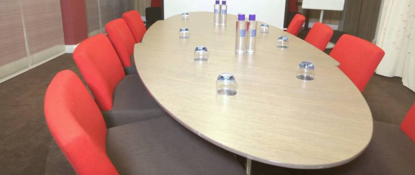 Albert Johnston in a professional meeting room at Novotel Liverpool Centre, featuring red-gray seating.