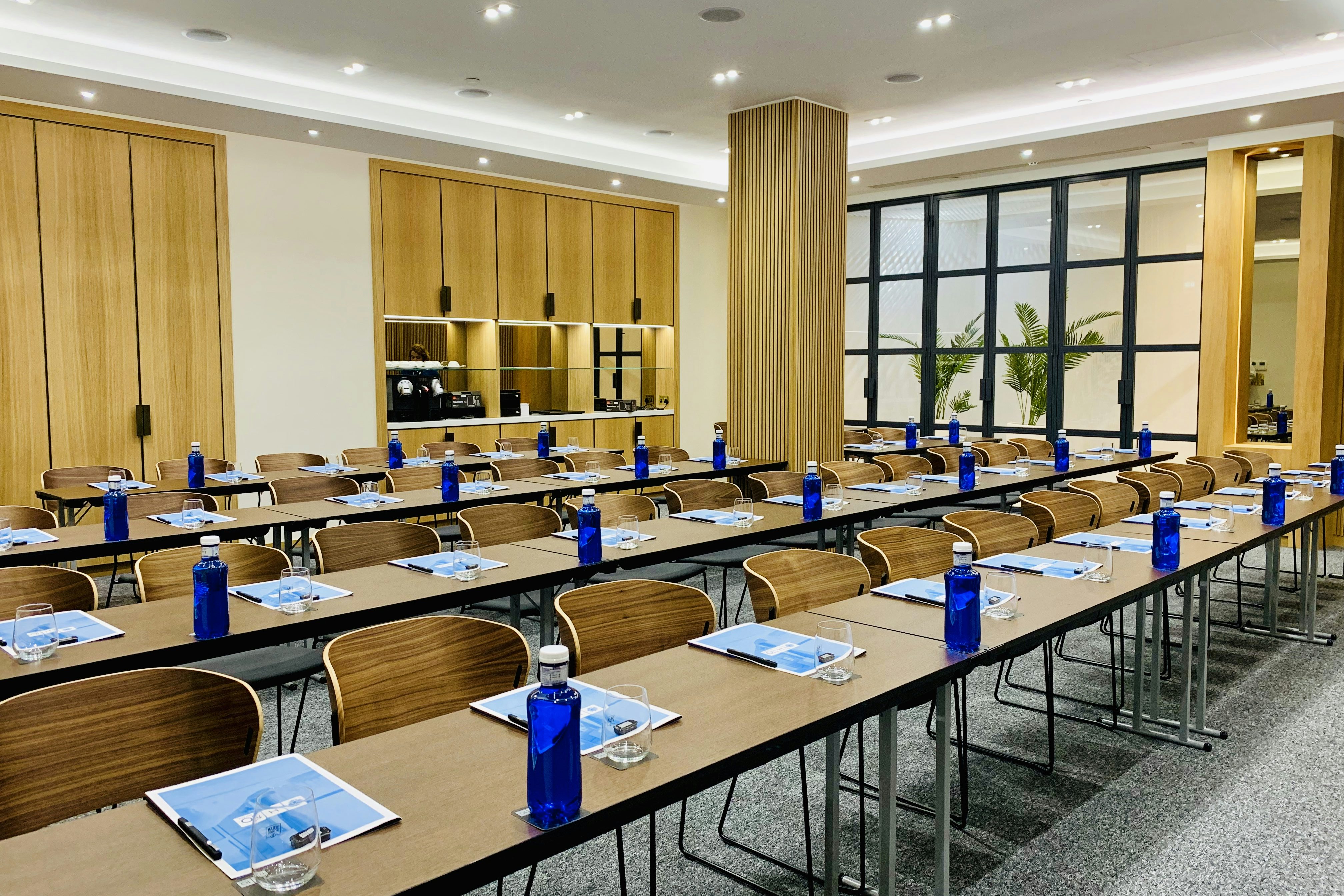 Modern workshop space at H10 London Waterloo with branded blue water bottles.