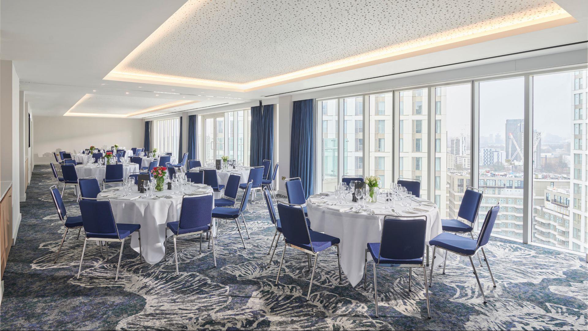 Event space at H10 London Waterloo with round tables for corporate meetings and gatherings.