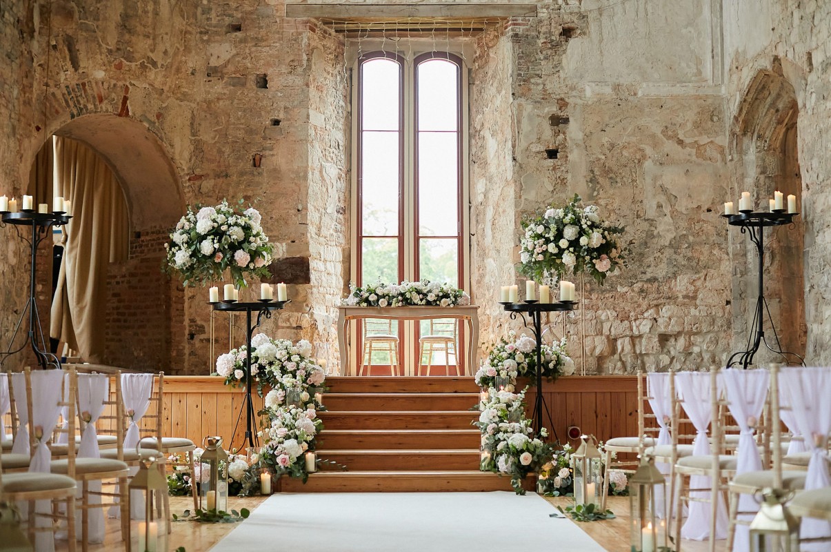 Luxury wedding venue at Lulworth House with stone architecture and floral aisle decor.