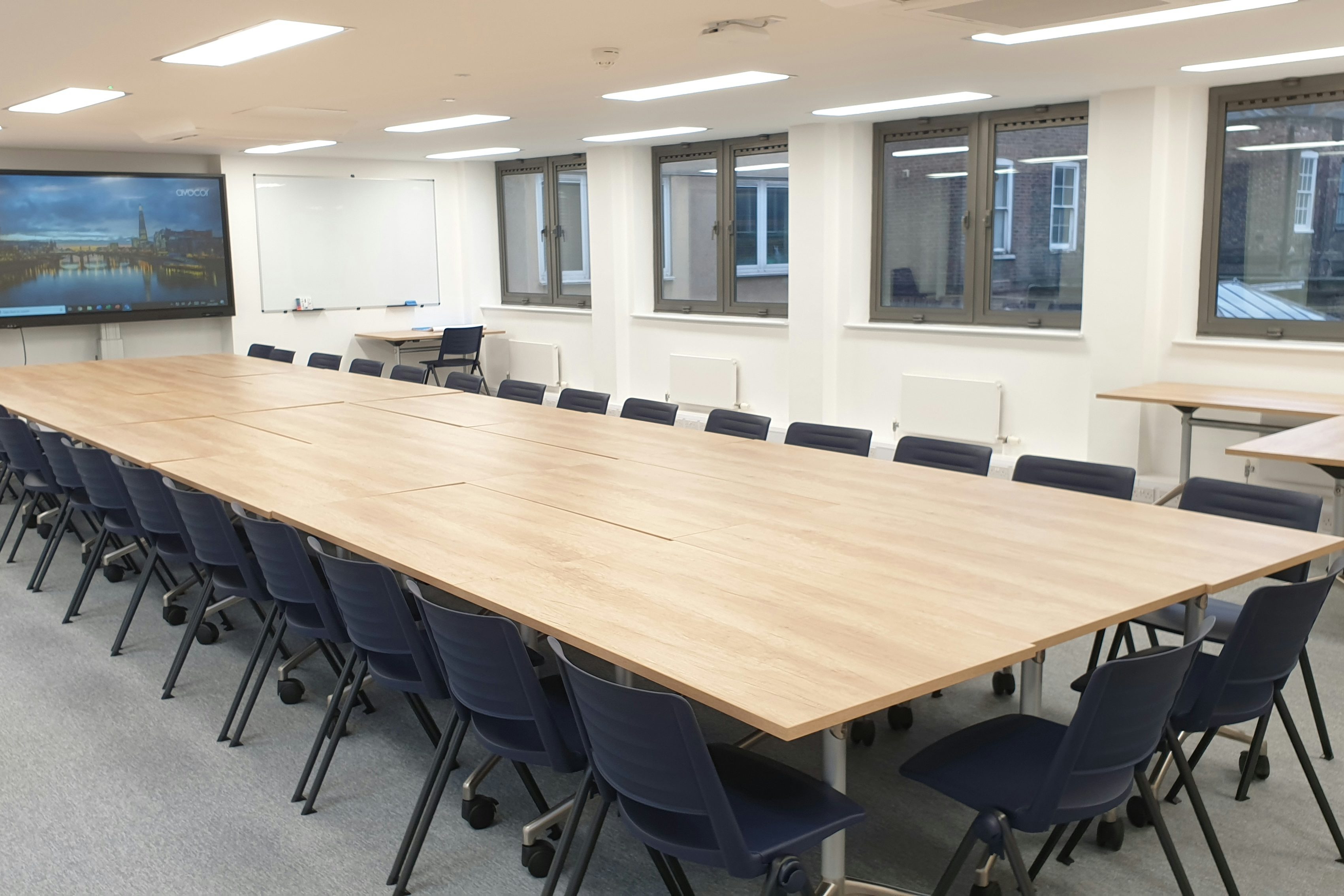Modern hybrid meeting room, interactive display, corporate event, training