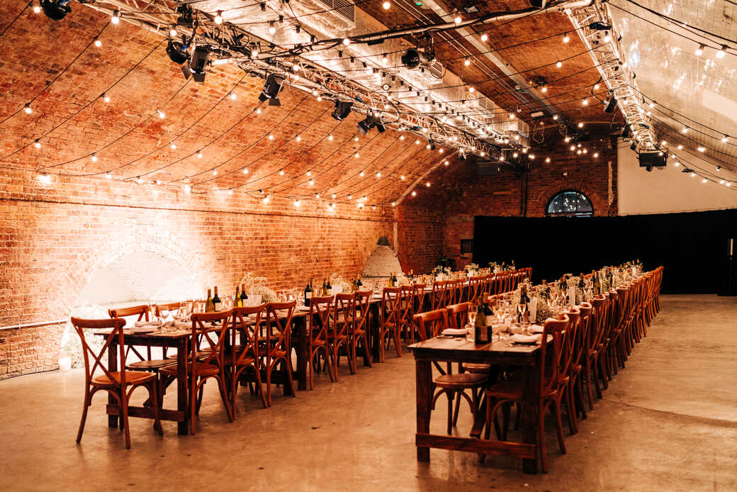 Industrial event venue, brick, string lights, corporate dinner, wedding reception