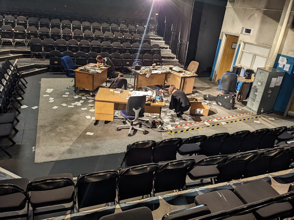 Theater post-event breakdown, chaotic setup.