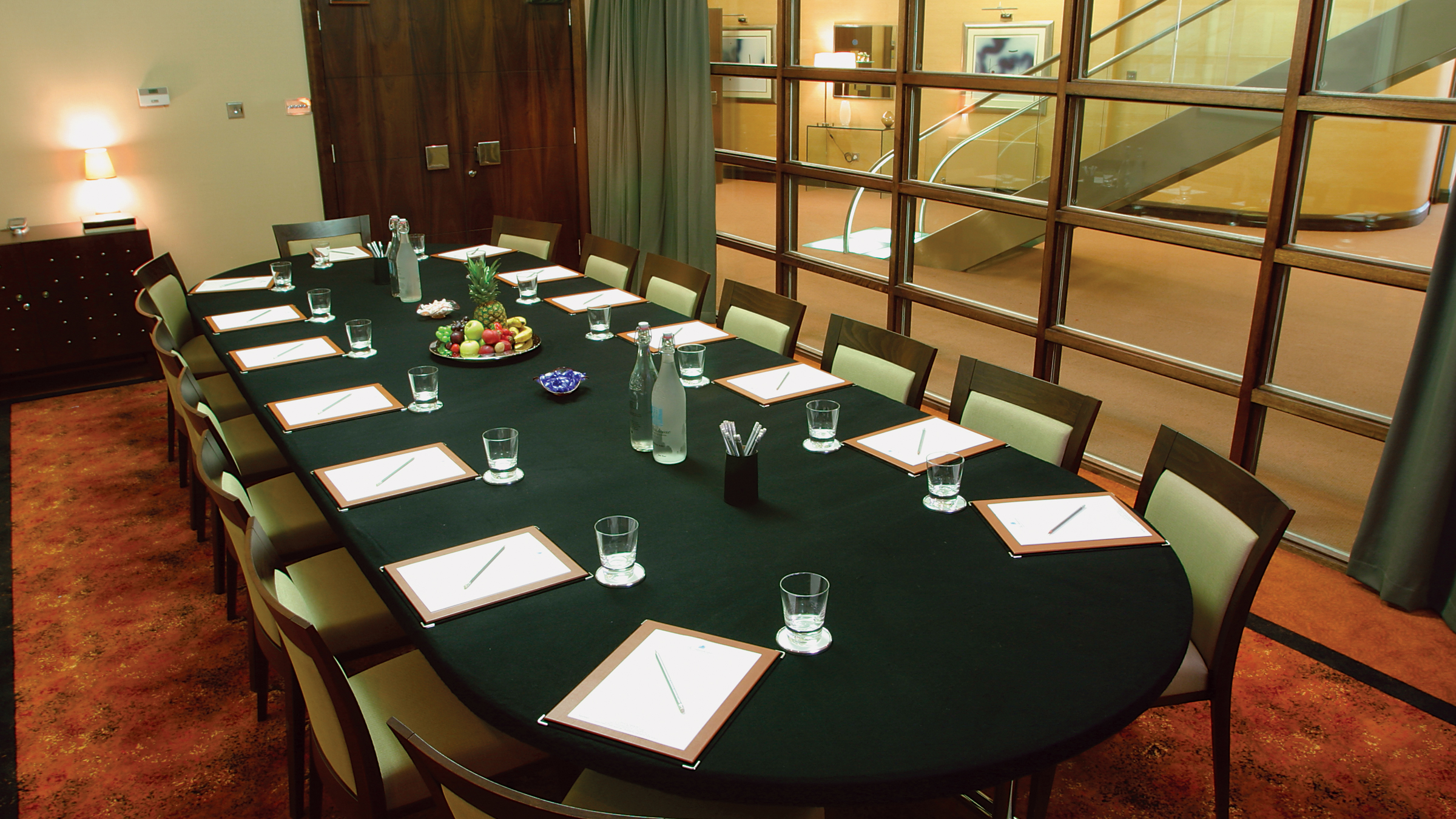 Glasshouse boardroom meeting, oval table, corporate event