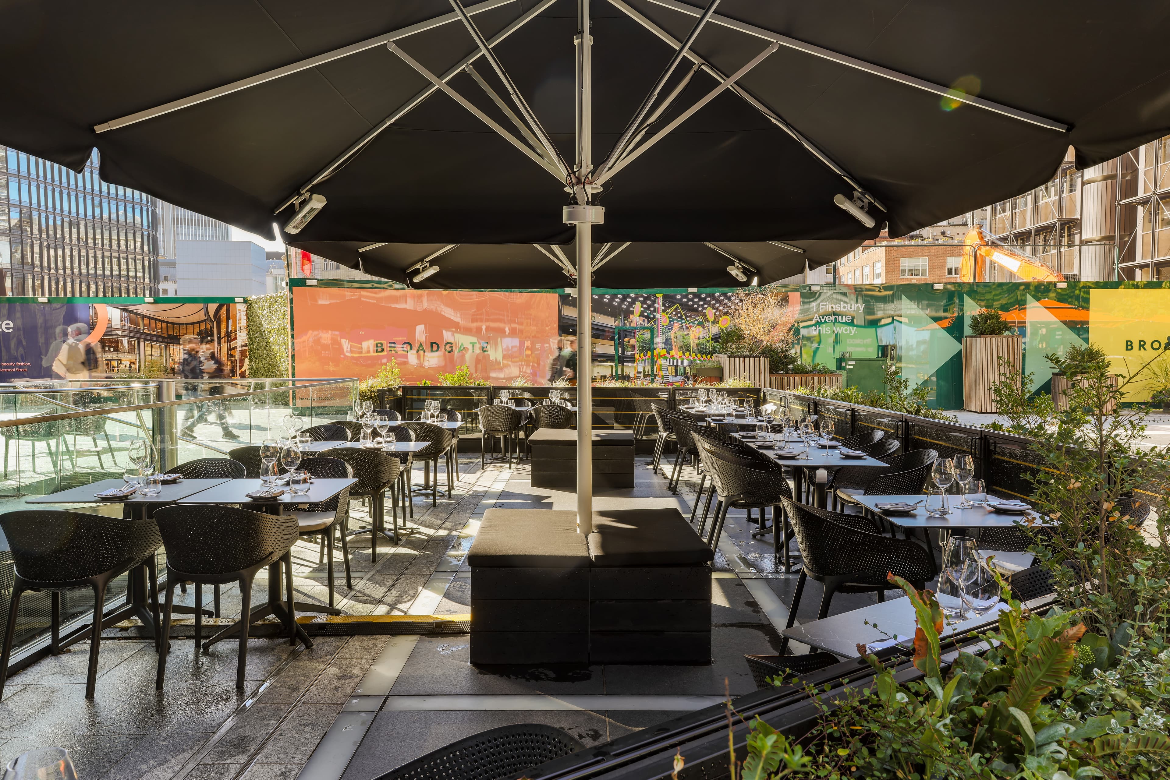 Glasshouse outdoor event space with seating & umbrellas