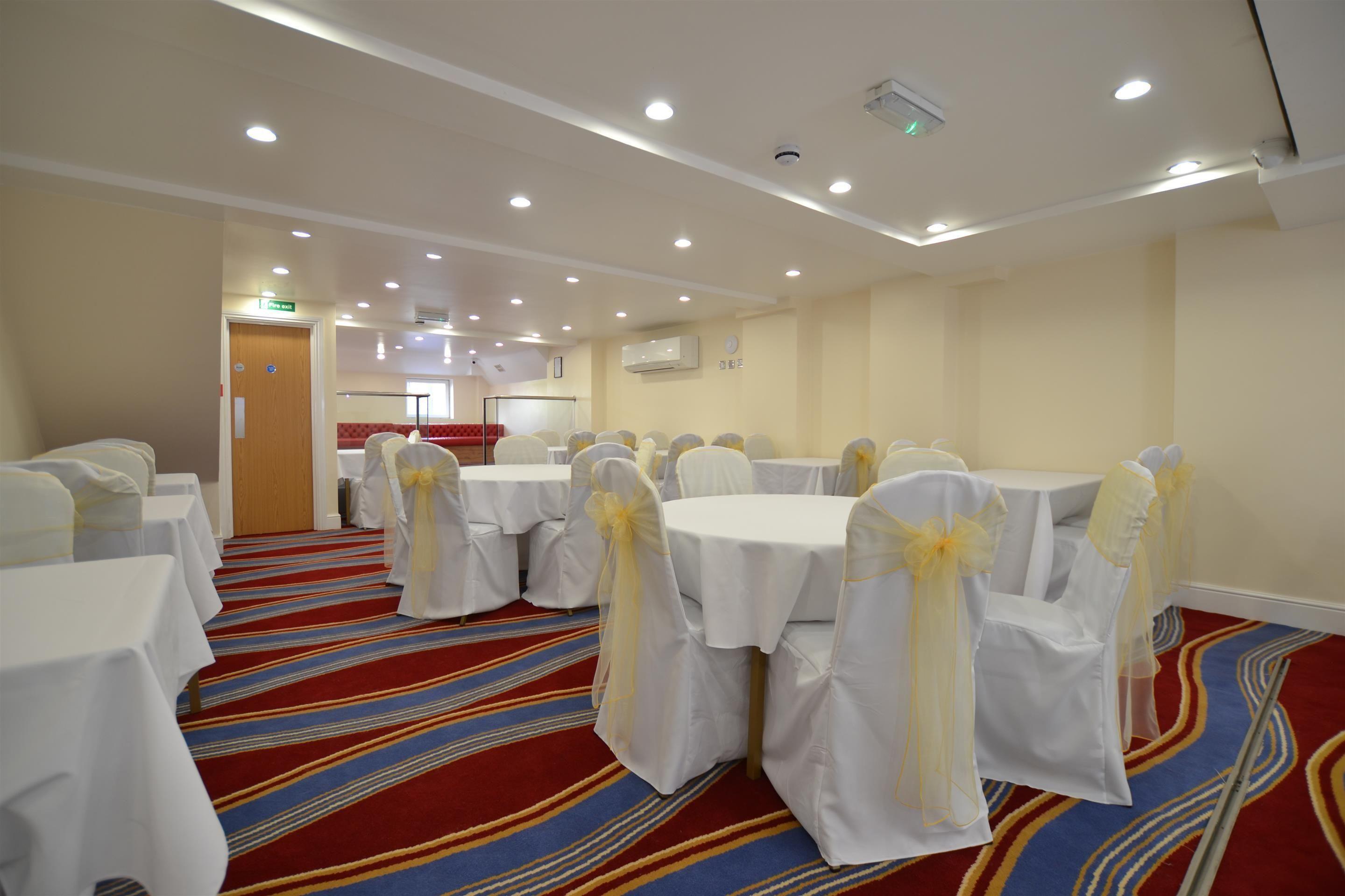 London hotel banquet hall, formal round tables, event space.