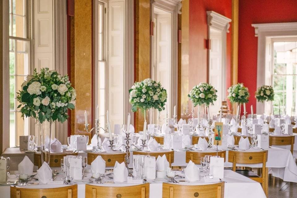 College Hall gala setup with tall floral centerpieces and elegant candelabras for luxury weddings.