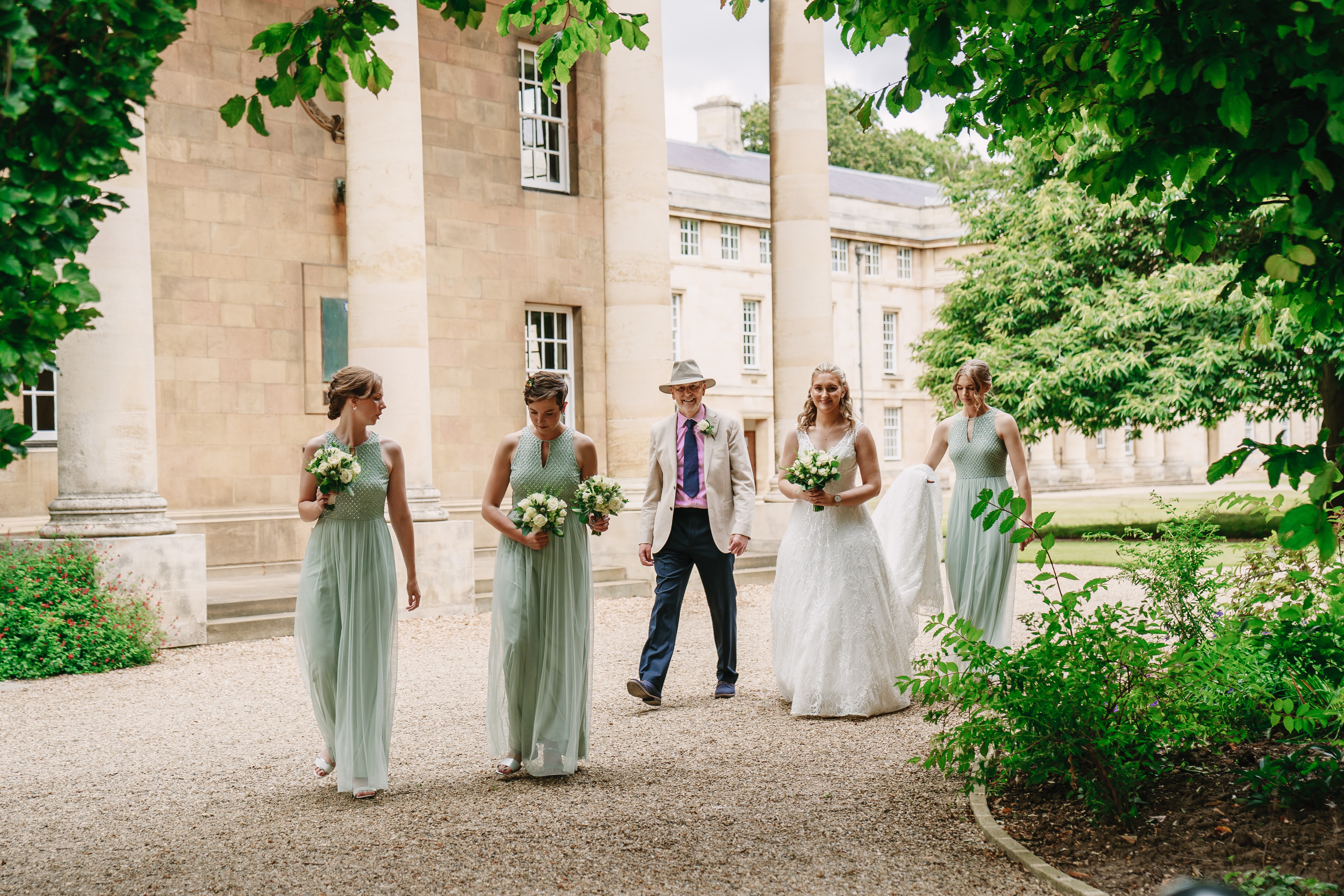 Wedding procession in historic Downing College Fellows' Garden for outdoor wedding venue.