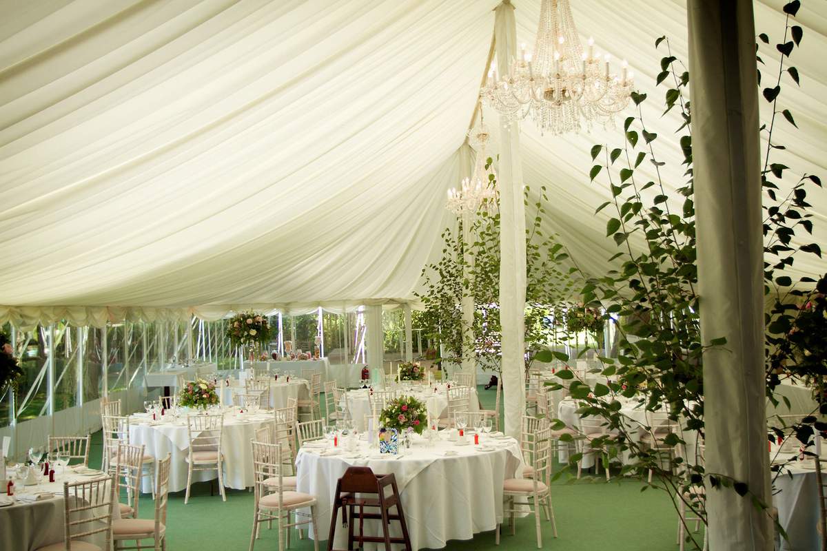 Luxury marquee wedding venue at Rectory Farm with crystal chandeliers and ivory linens.