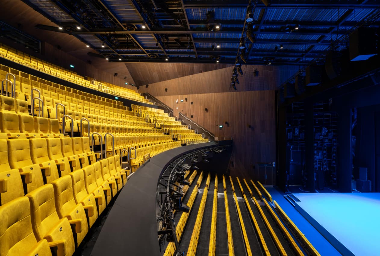 Aviva Studios auditorium with tiered yellow seating for keynote presentations and brand events.