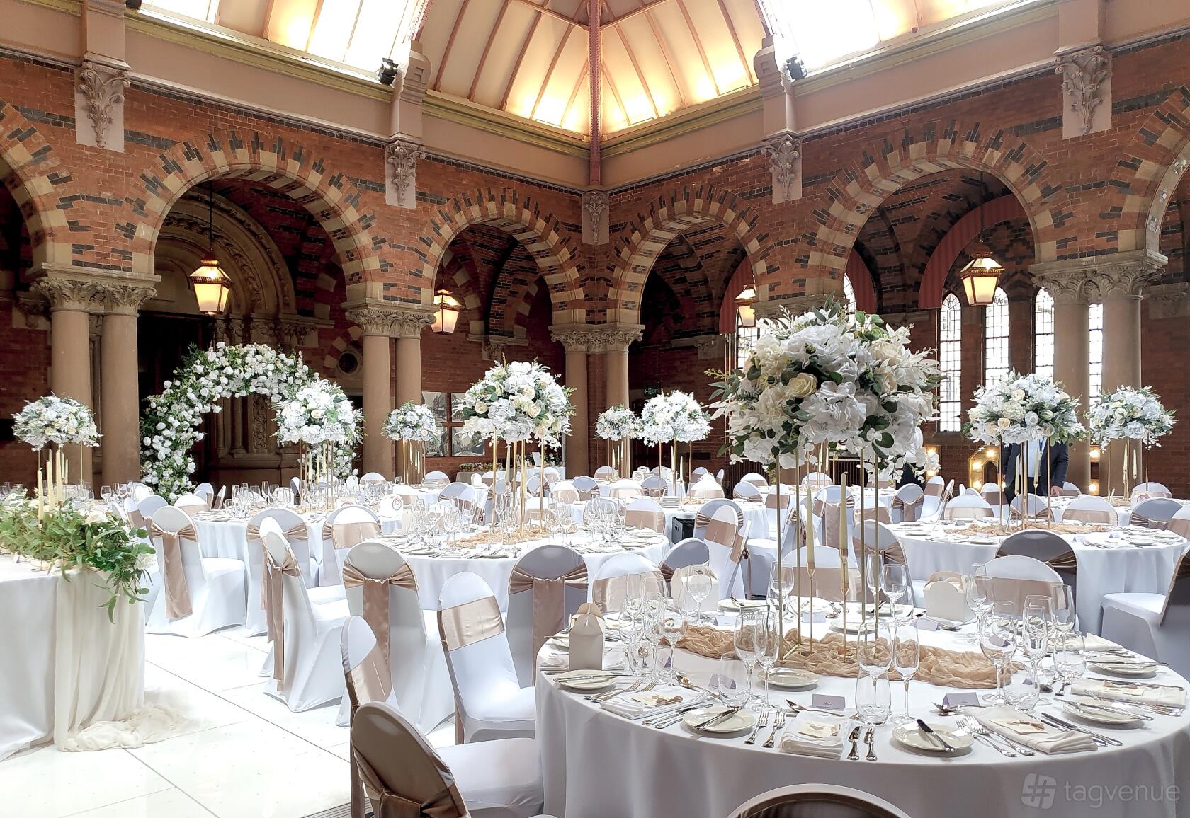 Elegant banquet dining room with floral centerpieces for upscale event or wedding venue.
