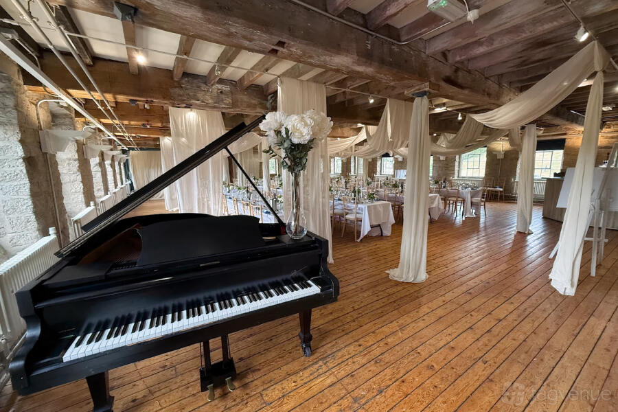 The Terminal Suite event space with industrial beams and grand piano for corporate and social events.