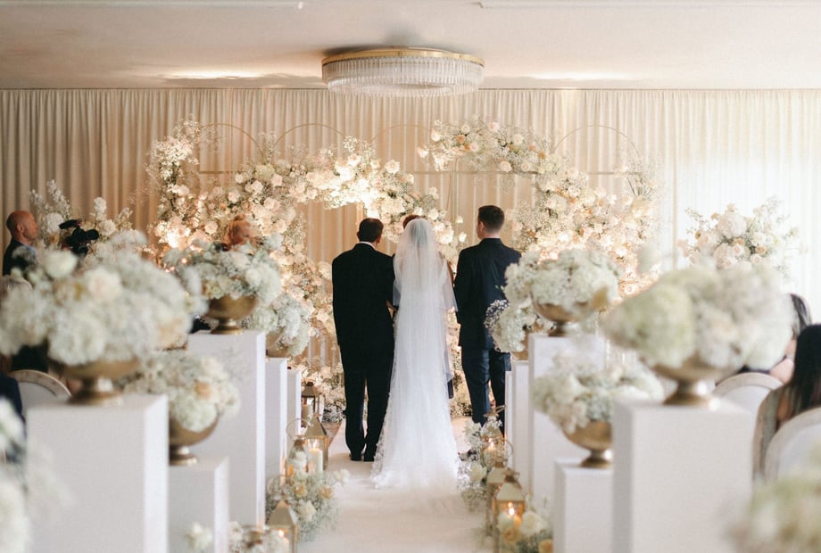 Monochrome wedding ceremony with lush floral pedestal styling at Chewton Glen Lake Suite.