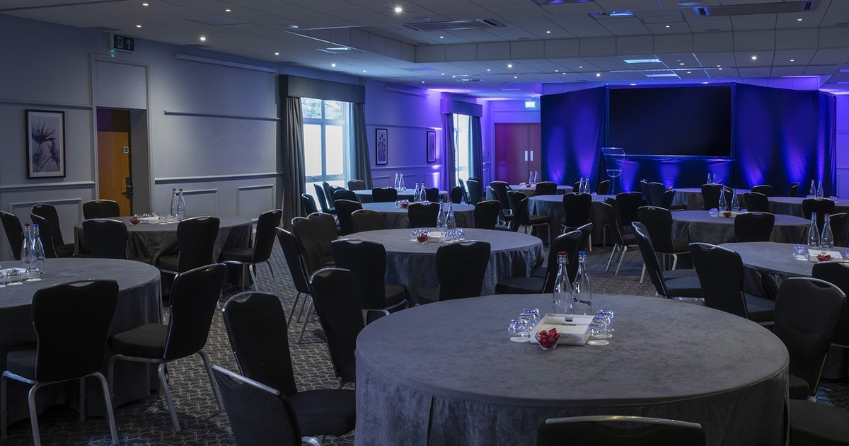 Stephenson Suite banquet setup with blue lighting for corporate gala or dinner event.