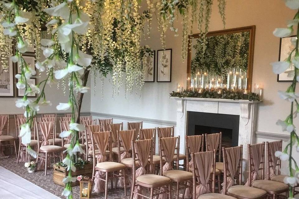 Appleton Suite wedding ceremony with floral decor and fireplace at De Vere Cranage Estate.