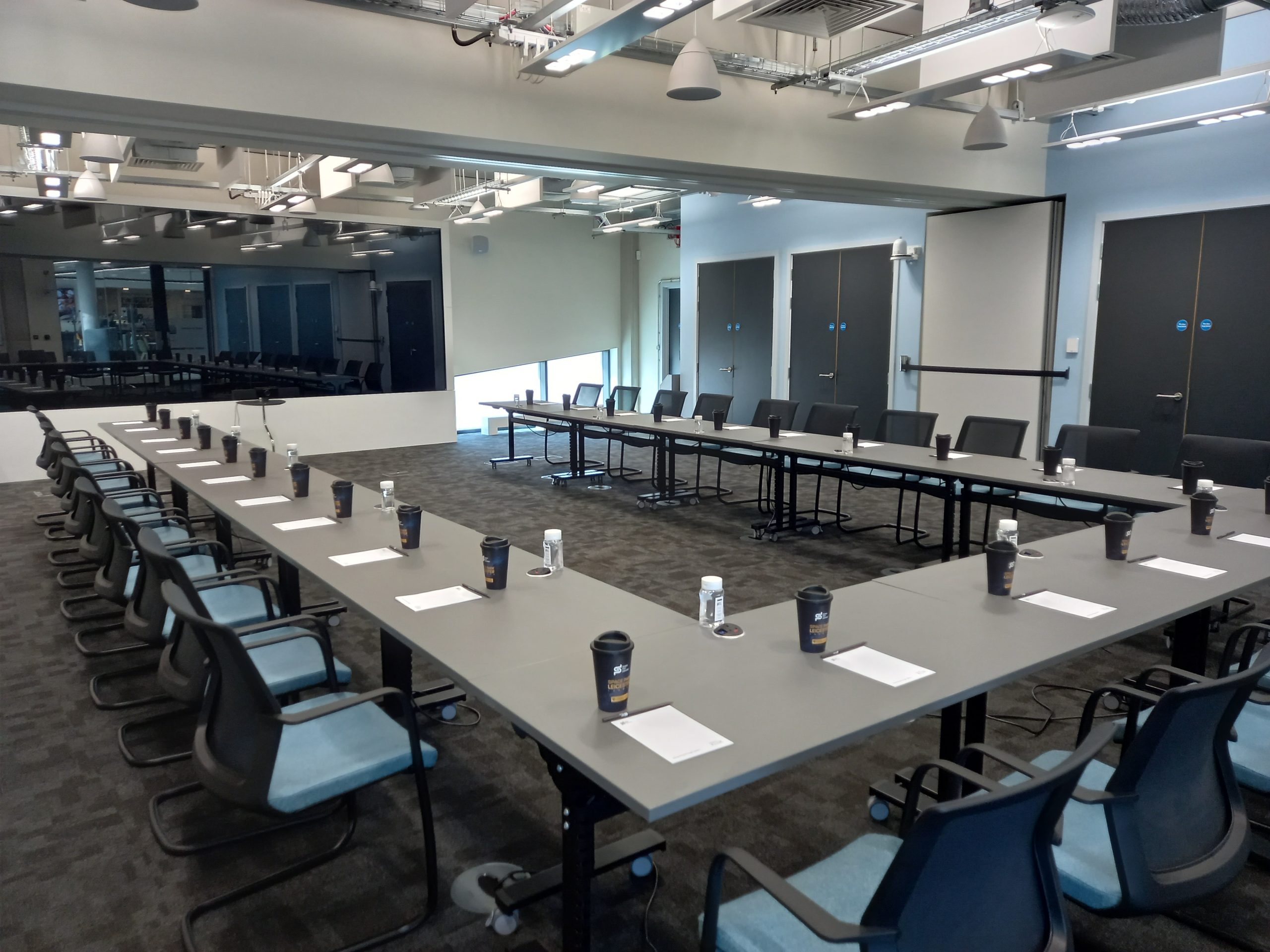 U-shaped training room with screen for professional corporate workshops and collaborative meetings.