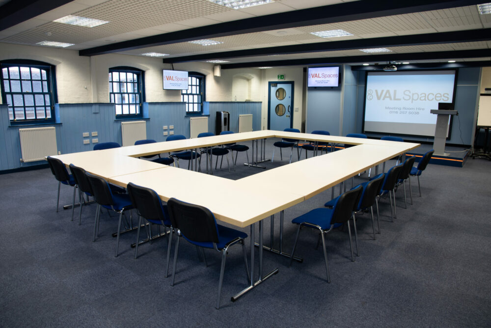 U-shaped boardroom in industrial training hub, ideal for professional workshops and meetings.