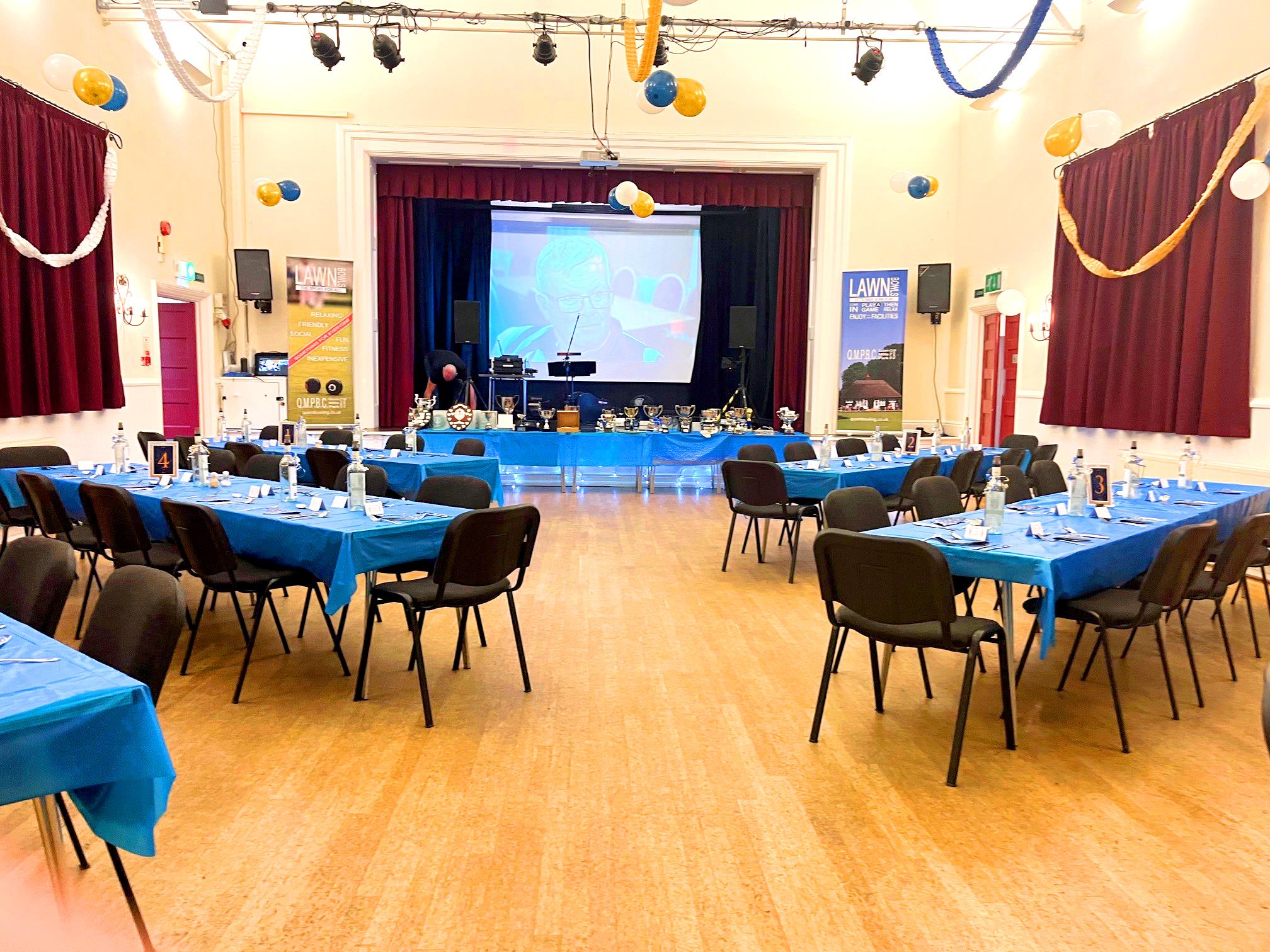 Main Training Room banquet setup with stage screen for corporate events and awards presentations.