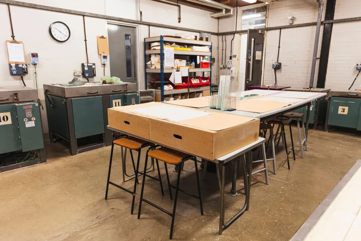 Industrial lampworking studio, cluttered workspace for creative event rental.