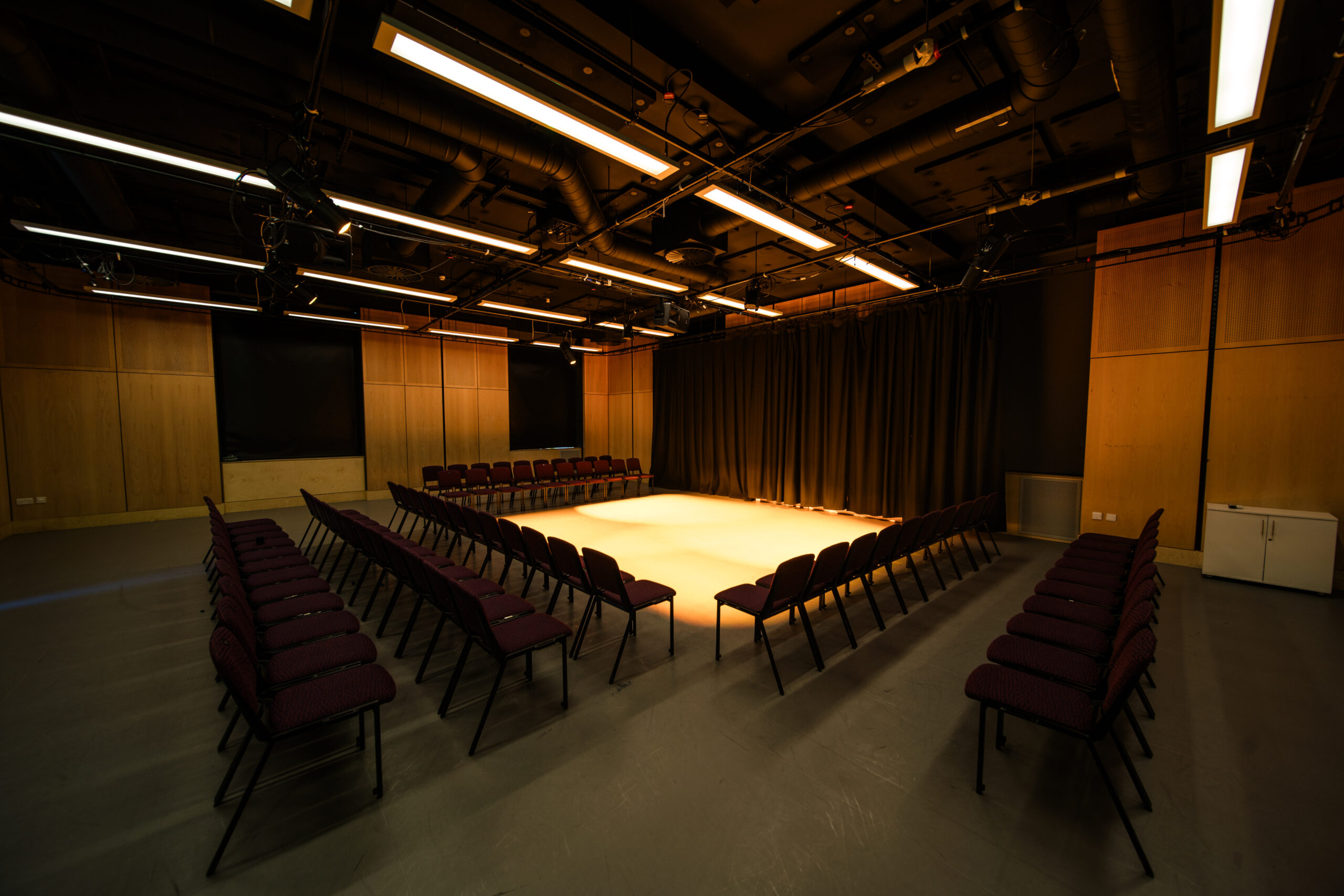 London Youth Theatre black-box studio with U-shaped seating for workshops and presentations.