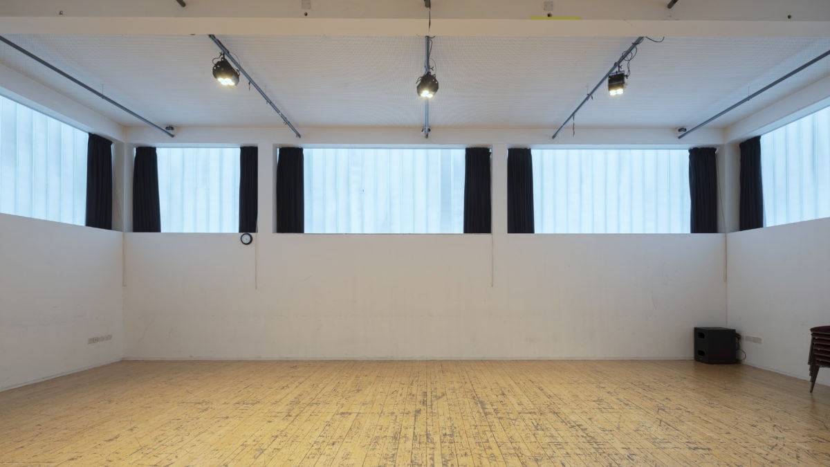 Industrial rehearsal space with wood floors for creative workshops and pop-up events.