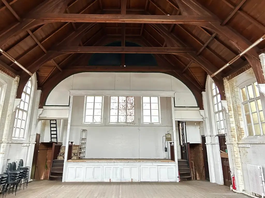 Rustic industrial event venue in St Stephen's Hall with exposed historical architecture.