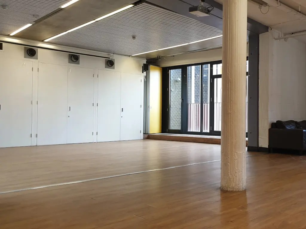 Main Hall event space at The Pirate Castle with wood floors, ideal for weddings and parties.