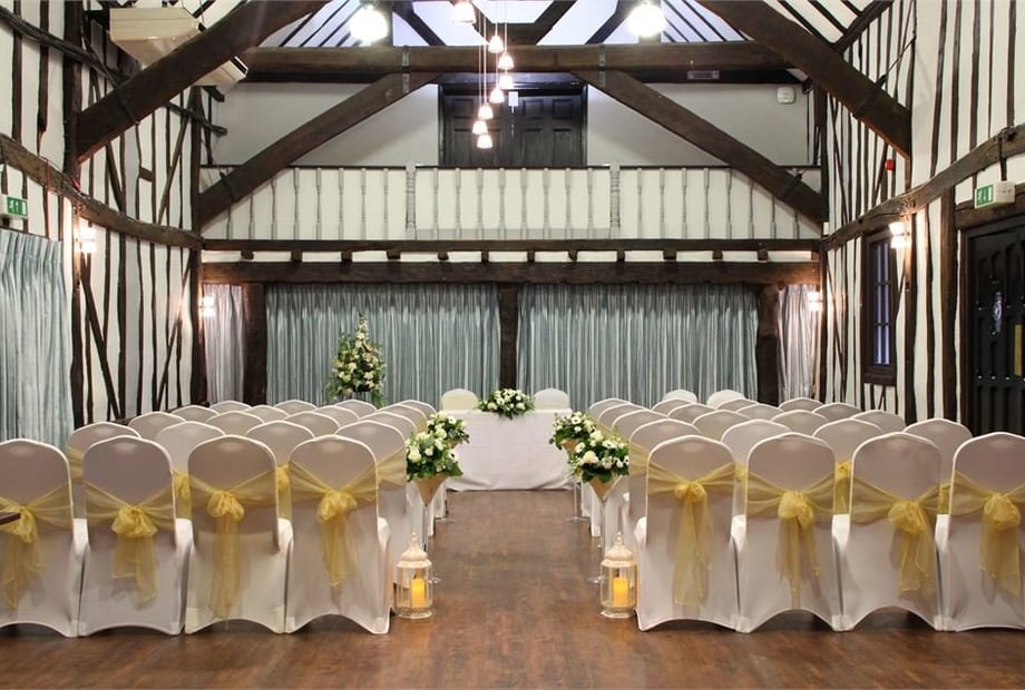 Rustic barn wedding venue at Stable Inn, Chichester Hotel with elegant aisle seating.