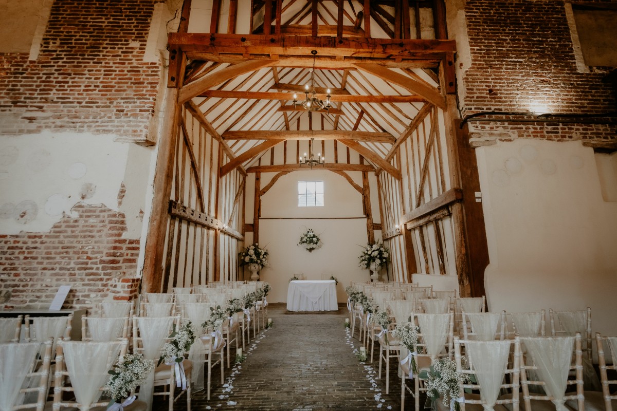 Rustic wedding ceremony venue at The New Chichester Hotel with exposed timber beams.