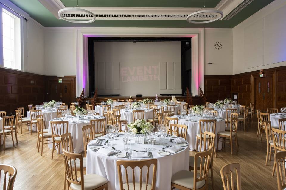 Main Hall stage with wood paneling, ideal for corporate conferences and formal gala events.