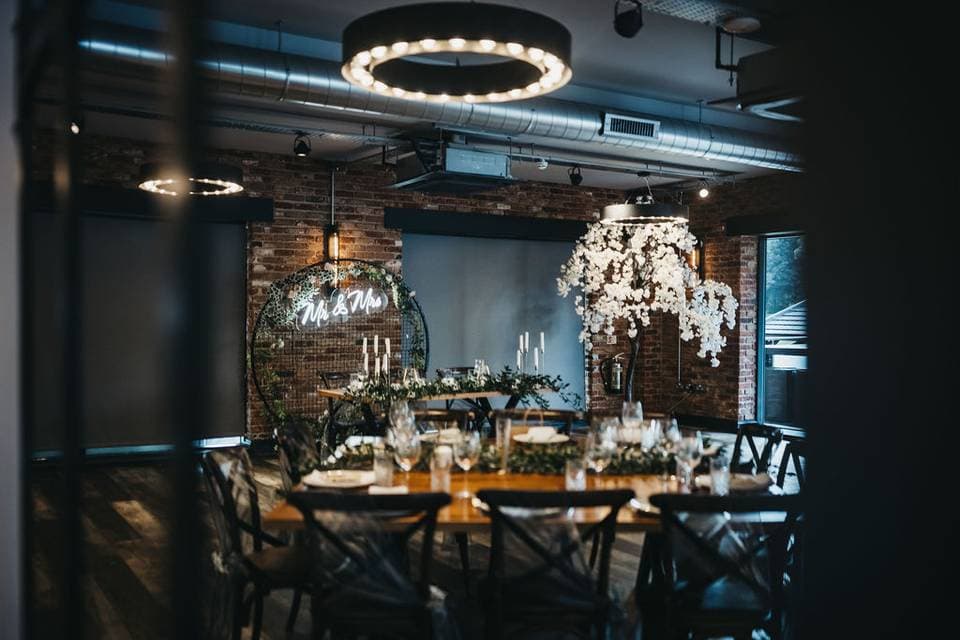 Industrial-chic wedding setup in Tollgate Suite at The Hurt Arms with neon sign and brick decor.