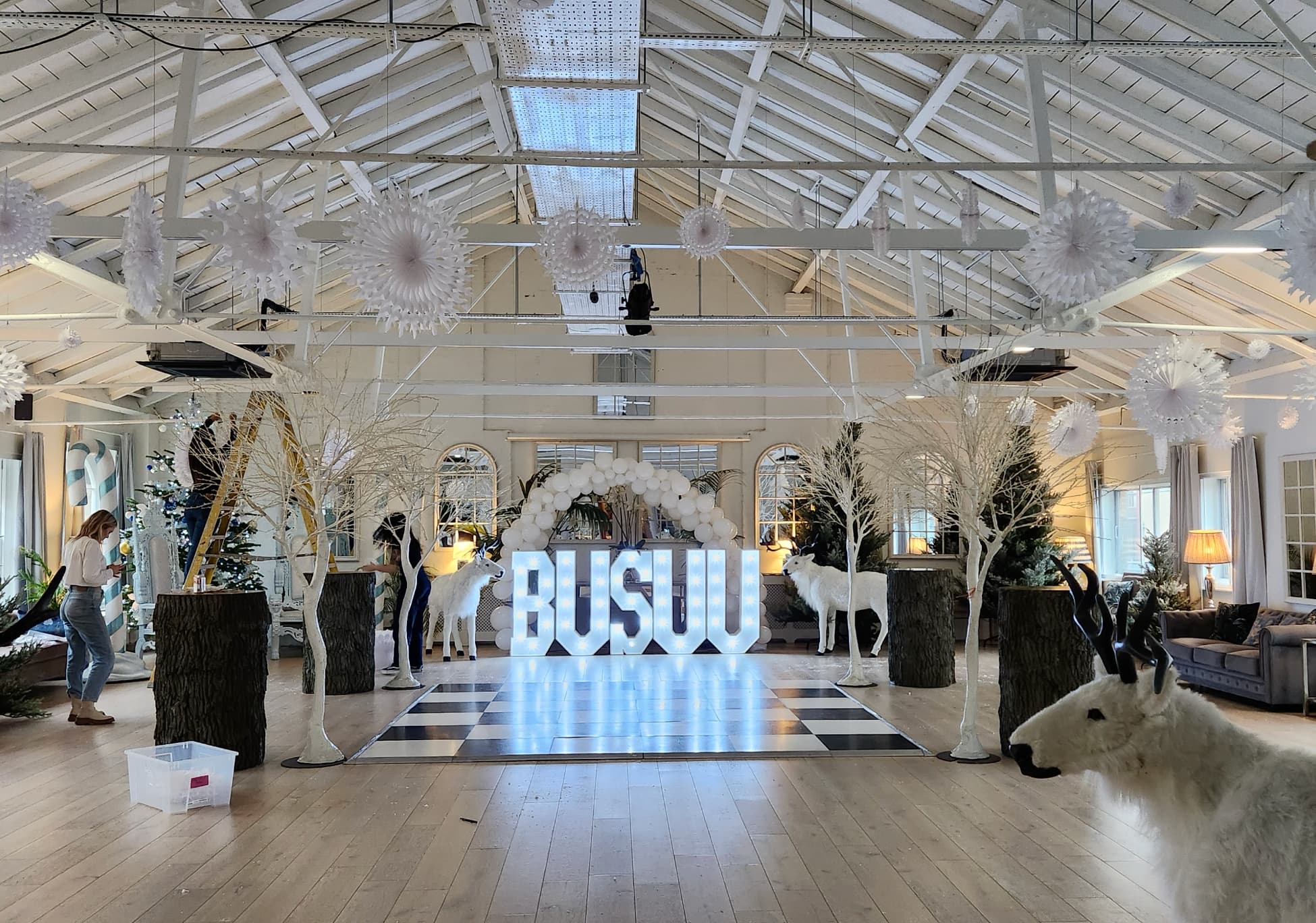 Winter-themed branded light installation and checkerboard dance floor for corporate event venue.